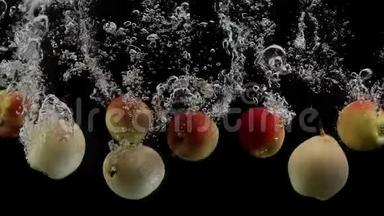 成熟的水果，五颜六色的苹果和黄色的<strong>梨子</strong>掉进水里，溅起水花和泡泡，黑色的背景
